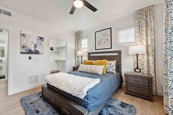 A bedroom with a bed, nightstand, and a ceiling fan. at The Laurel Apartments, Arizona